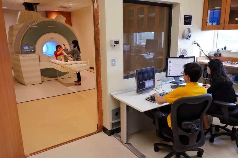 Brooks Casas and Jungmeen Kim-Spoon sit at a desk to analyze brain scans of a research participant at the Fralin Biomedical Research Institute. Photo courtesy of Jungmeen Kim-Spoon.