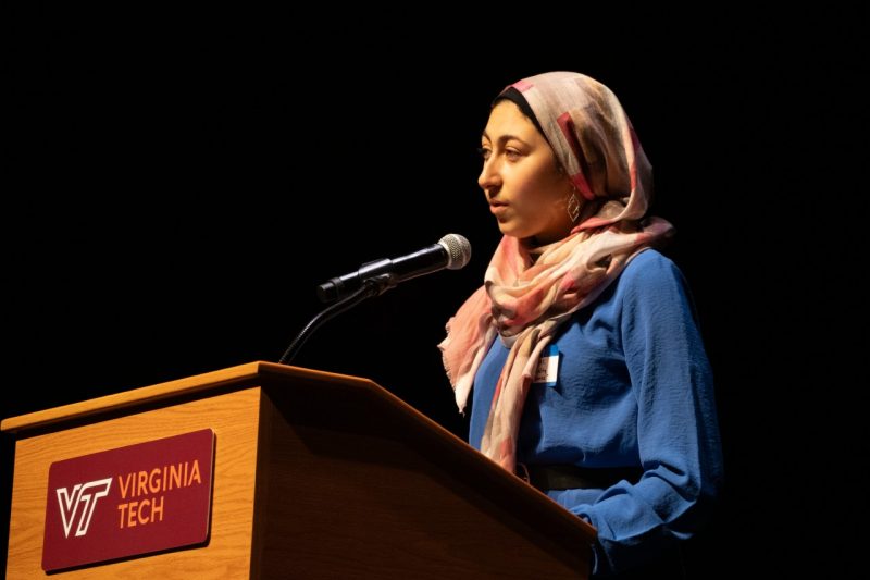 Ayah Ali stands a the podium, reading her first place poem "The Ephemerality of Incense" at the Giovanni-Steger Poetry Prize competition. 