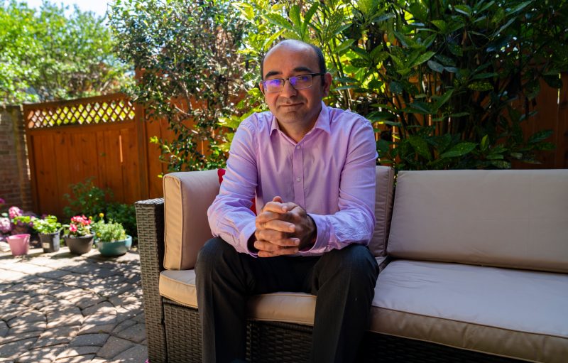 Associate professor Navid Ghaffarzadegan relaxes outside on his patio. 